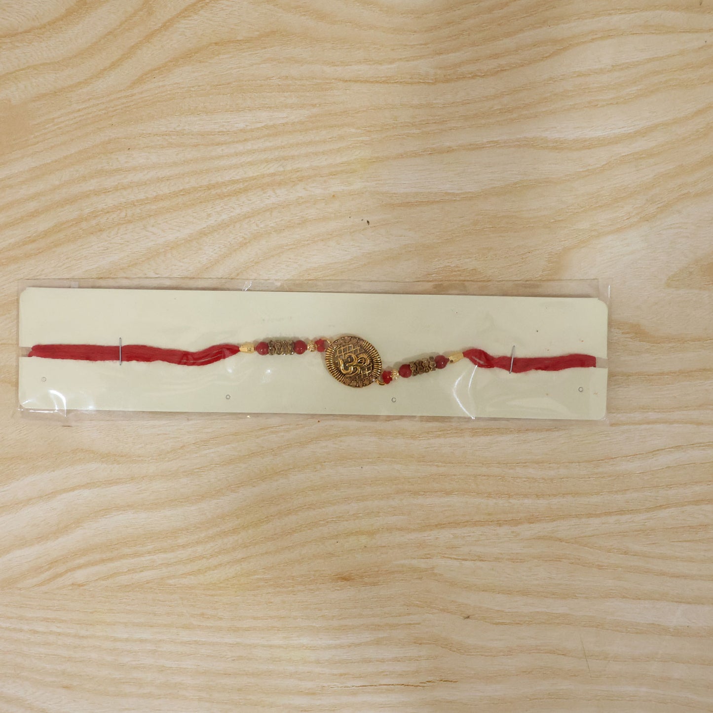 Om Coin Stone Rakhi with Red Beads and Blue Velvet Look