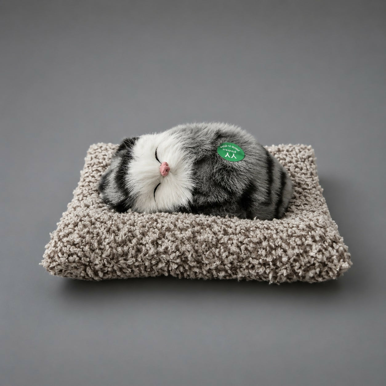 Sleeping cat plush toy displayed on office desk