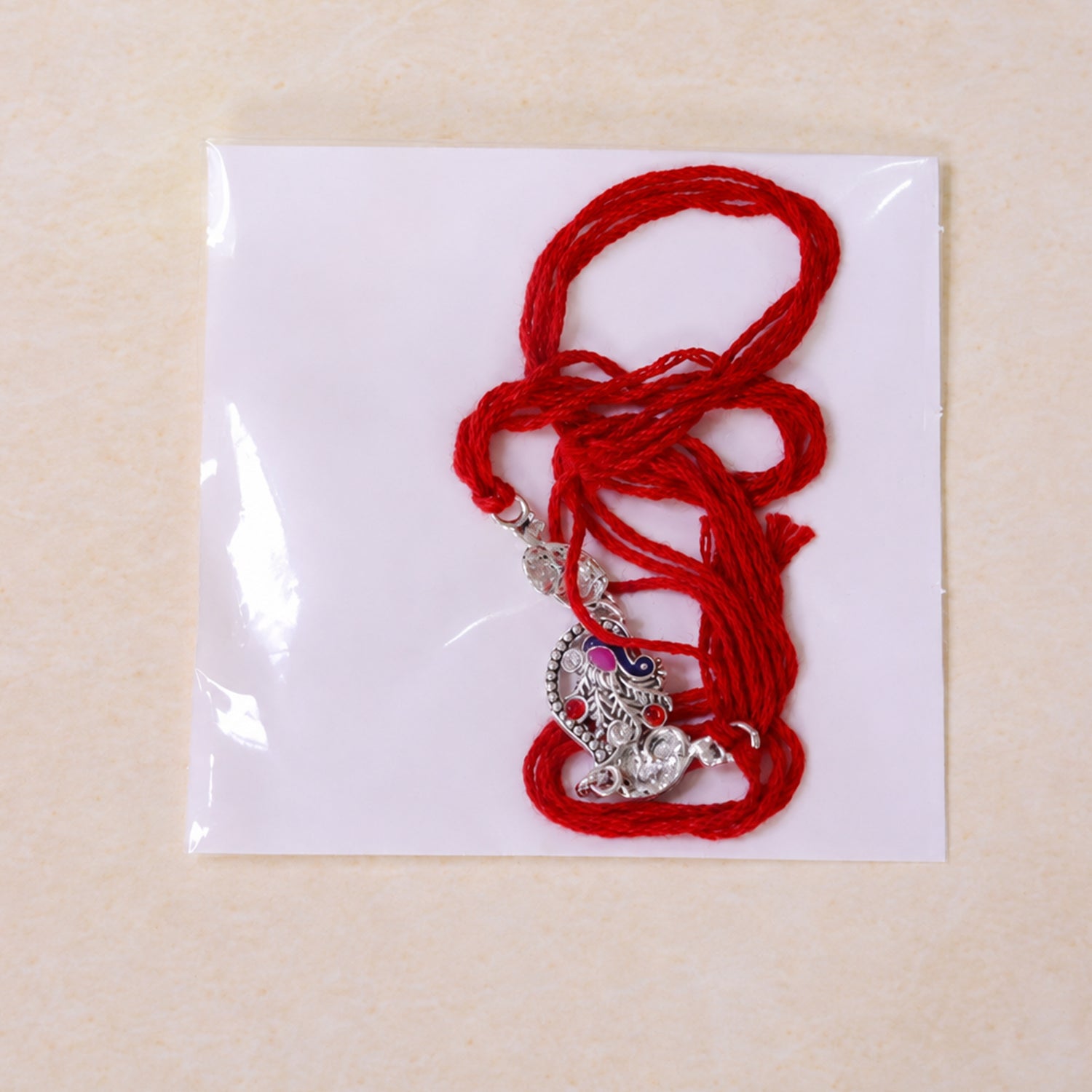 Silver-Toned Peacock Rakhi with Pink-Blue Enamel, Crystal Accents & Red Thread for Brother