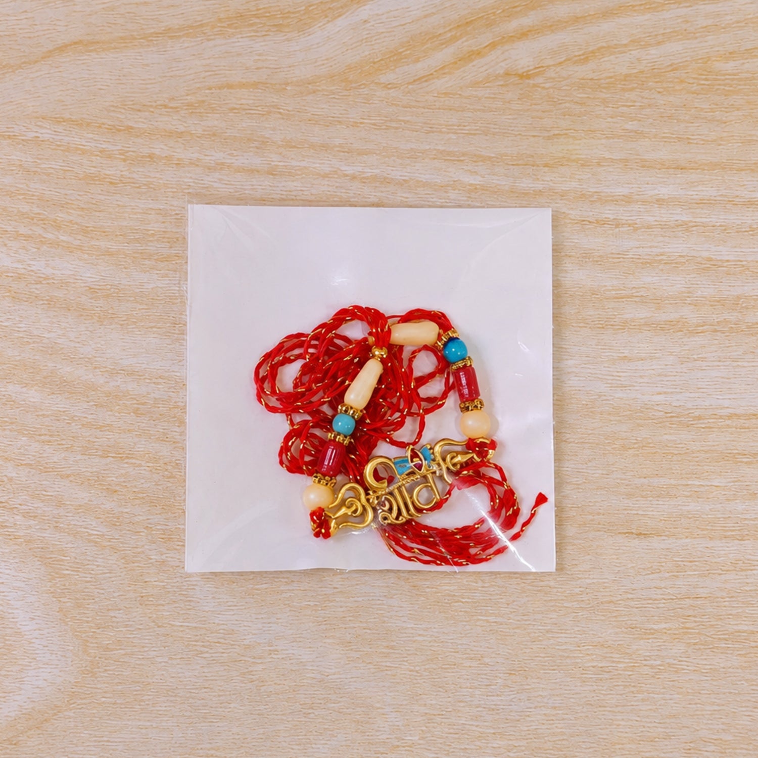 Shiv Script Pendant Rakhi with Blue Trishul Accent and Pearl Beads