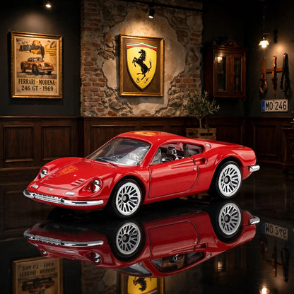 A bright red Hot Wheels Ferrari with white multi-spoke wheels, sitting on a reflective floor in a room with wood paneling,