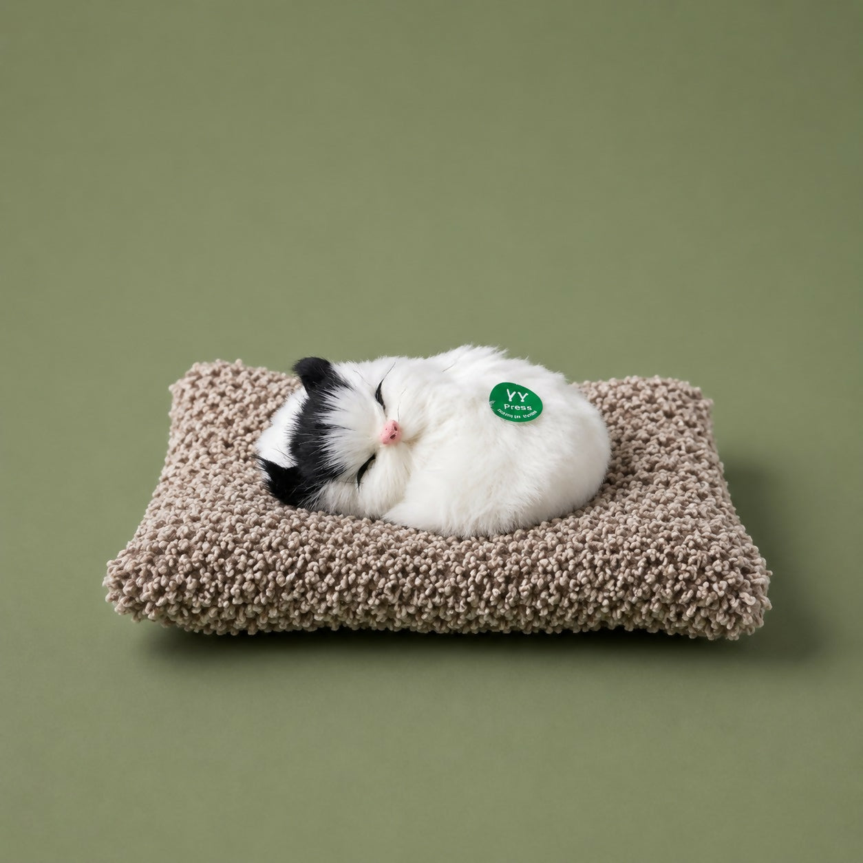 Sleeping cat plush toy shown on car dashboard