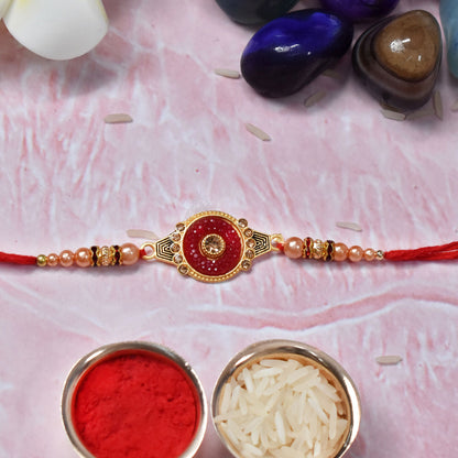 Red kundan rakhi featuring pearl beads in traditional design close-up