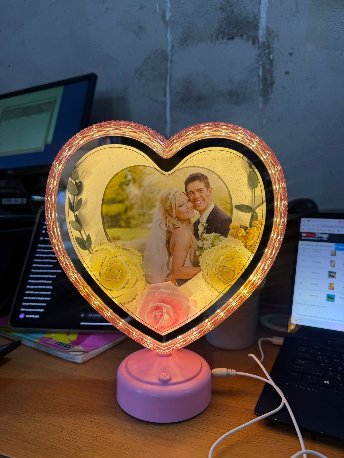 Heart shape LED photo frame glowing softly on bedside table