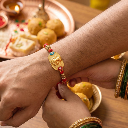 Golden Ganesh Rakhi for Boys with Red and Green Beads