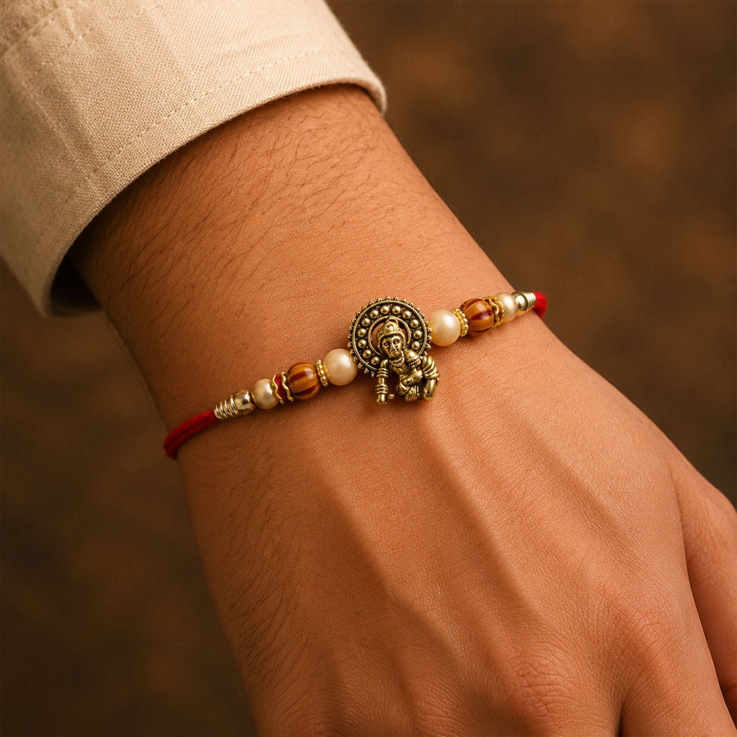 Antique Deity Idol Devotional Rakhi with Golden Medallion, Peach Beads and Red Thread