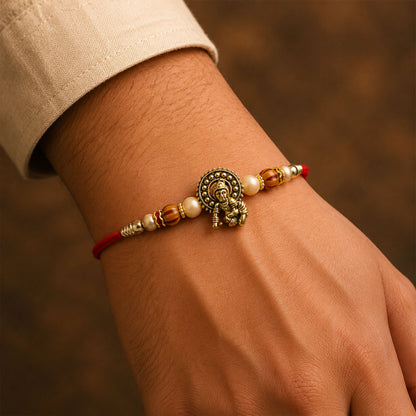 Antique Deity Idol Devotional Rakhi with Golden Medallion, Peach Beads and Red Thread