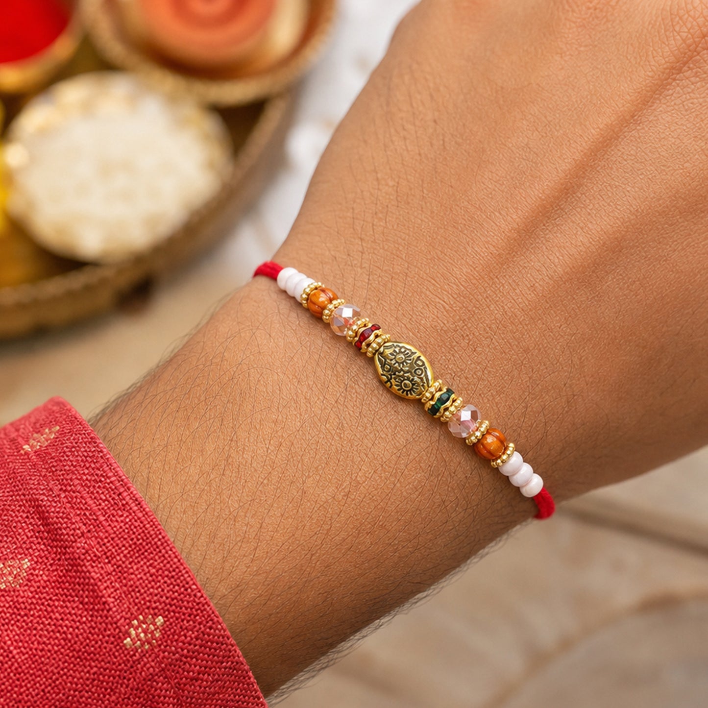 Red Thread Rakhi with Floral Gold Oval Charm and Multicolour Beads
