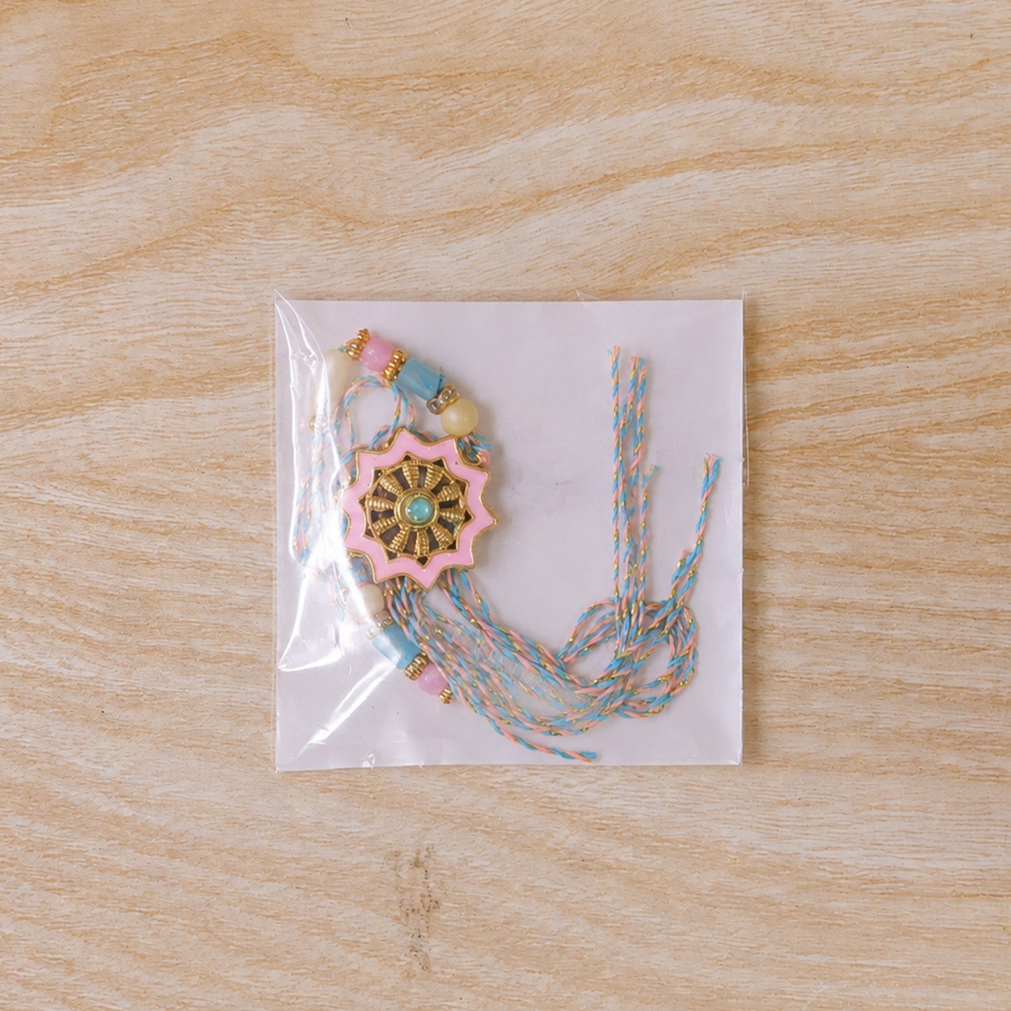 Pastel Floral Charm Rakhi with Pink Blue Beads and Elegant Festive Gift Styling Ideas