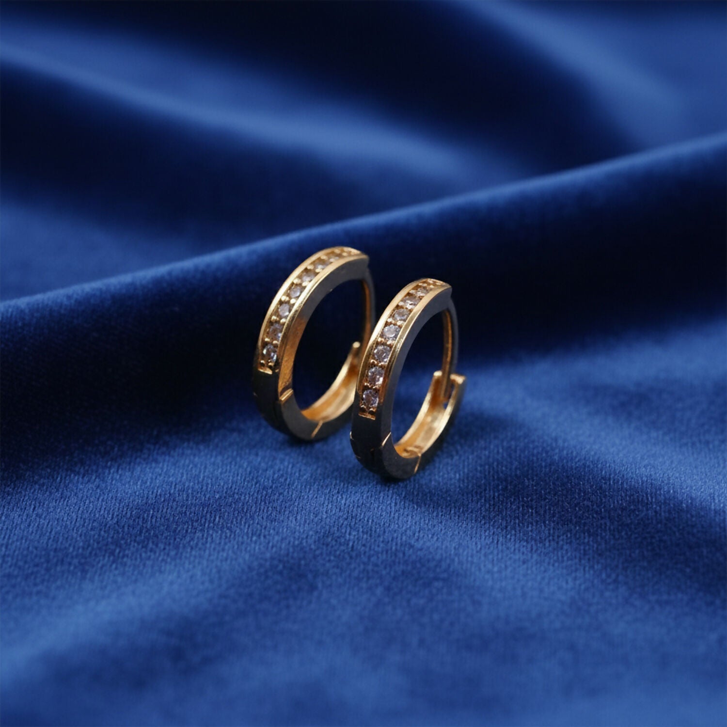 Close-up of sparkling crystal-studded gold finish hoop earrings for women and girls