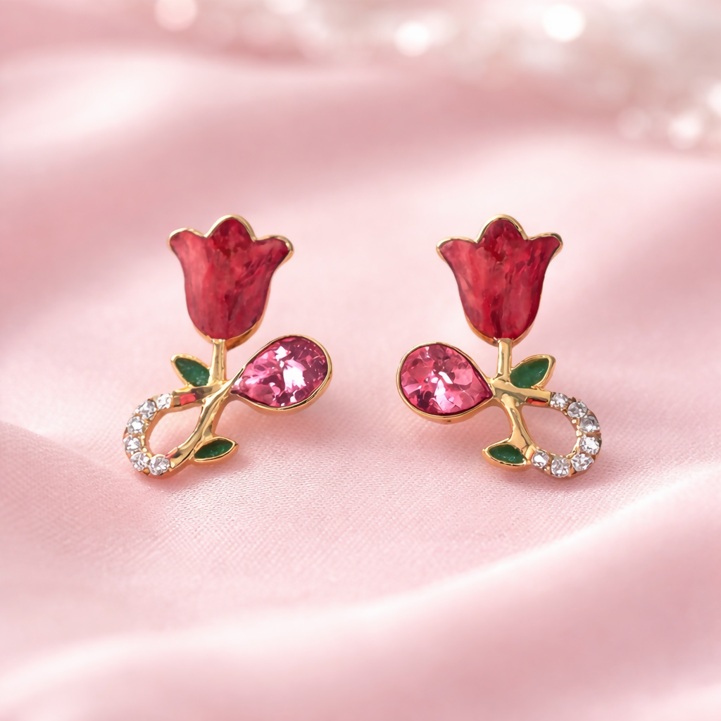 Pair of gold plated rose floral crystal stud earrings on a surface
