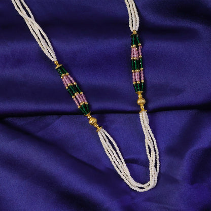 Pearl mala necklace draped over traditional fabric background