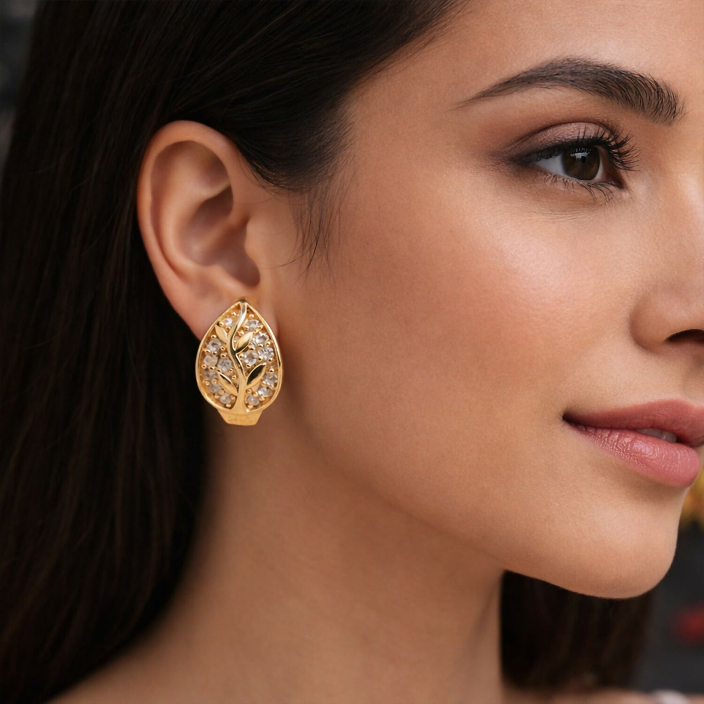 Close-up of leaf pattern stone stud earrings in gold-tone finish