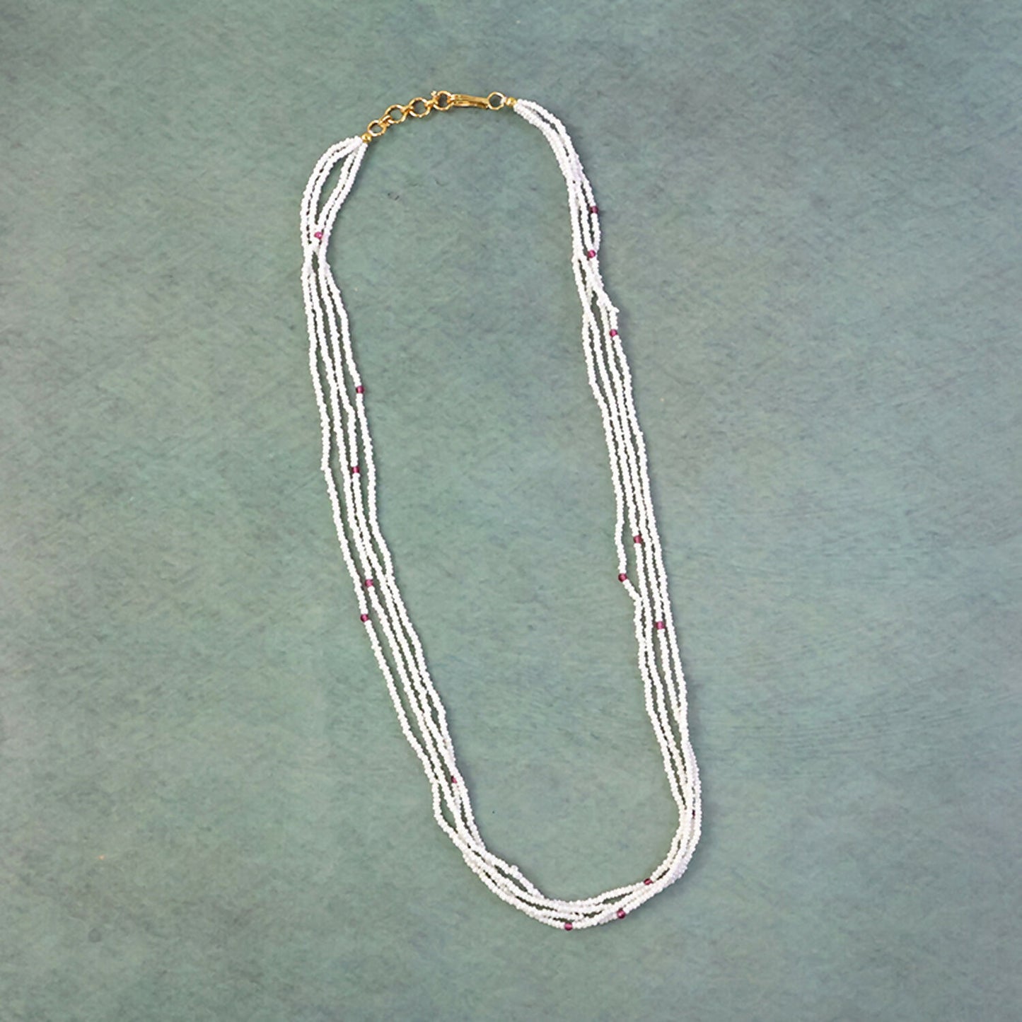 Close-up of pearl beads and pink detailing on a mala necklace