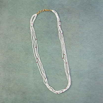Close-up of pearl beads and pink detailing on a mala necklace