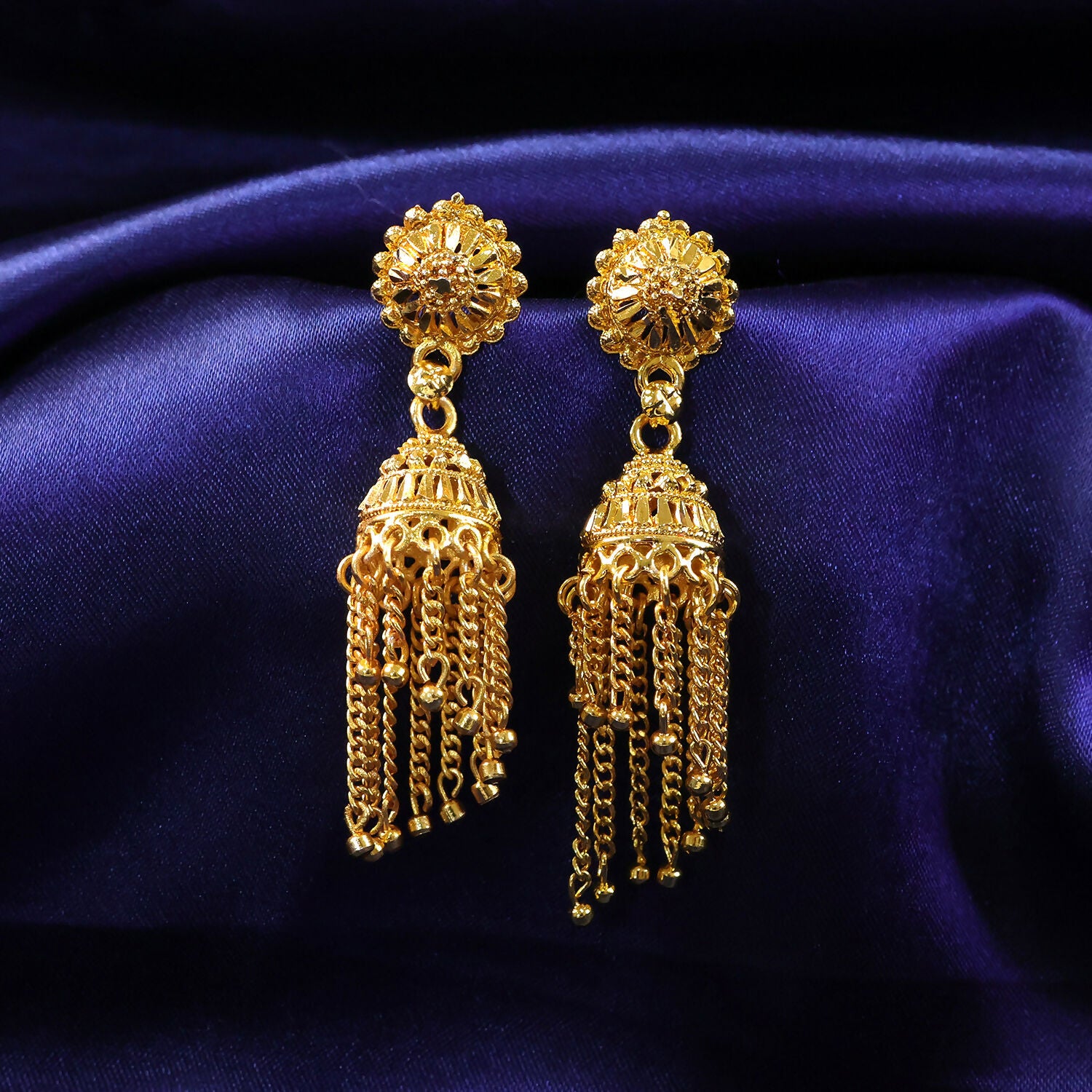 Front view of gold plated jhumka earrings with intricate design