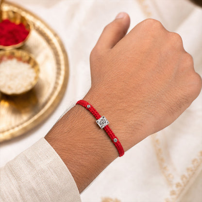 Red Braided Rakhi with Silver Om Pendant Set in a Square Frame