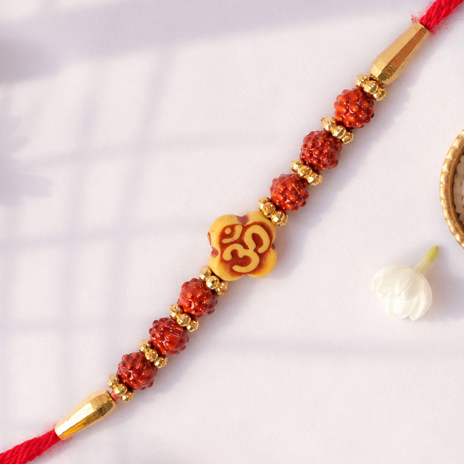 Om Bead Rakhi with Red Brown Accents and Spiritual Festive Brother Gift Styling Ideas