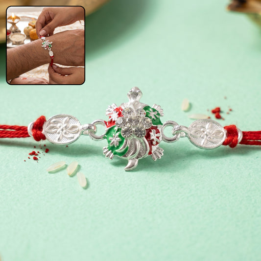 Turtle Rakhi with red thread and crystal embellishments front view