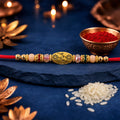 Red Thread Rakhi with Multicolour Beads and Gold Oval Floral Charm