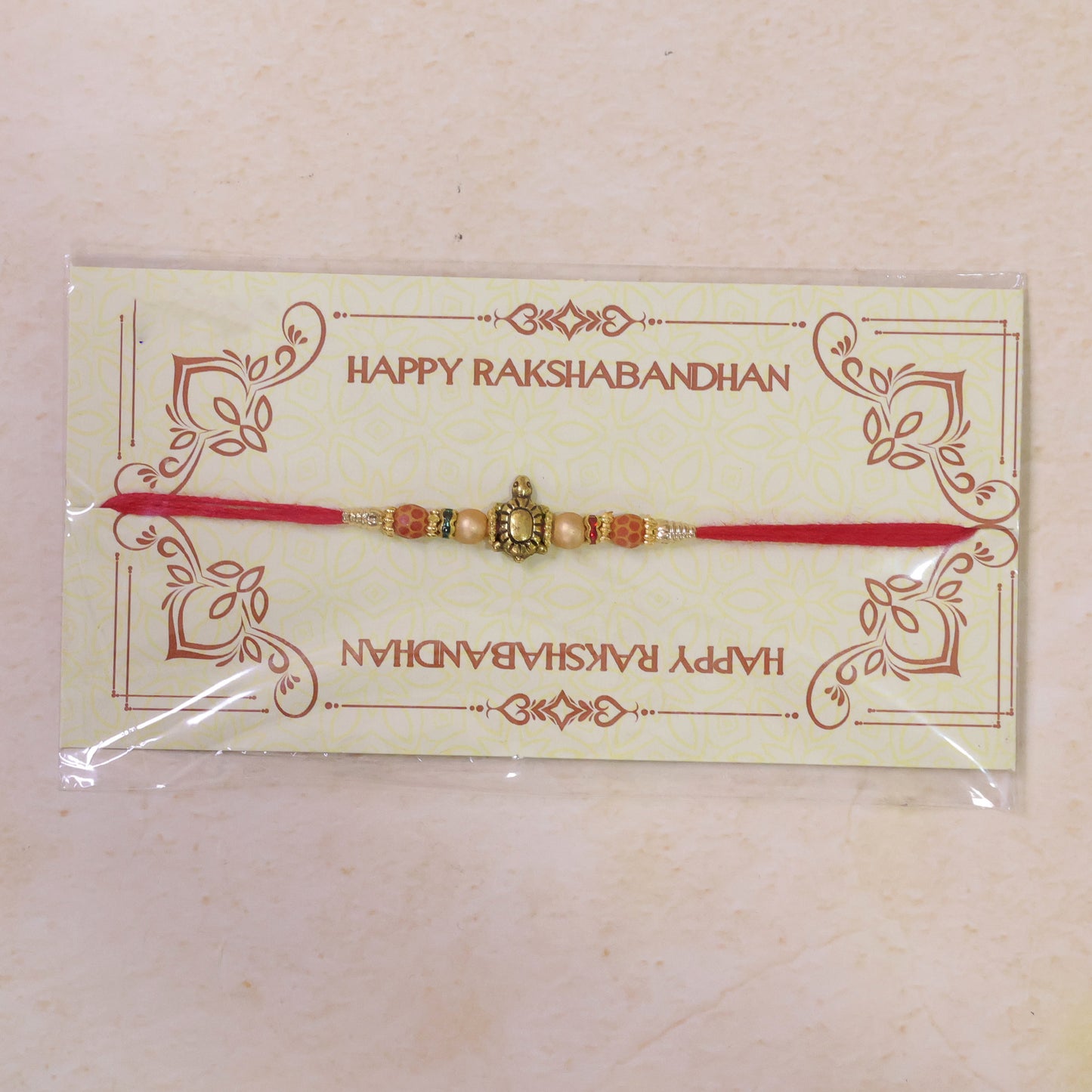 Red Thread Rakhi with Antique Gold Turtle Pendant and Beaded Accents