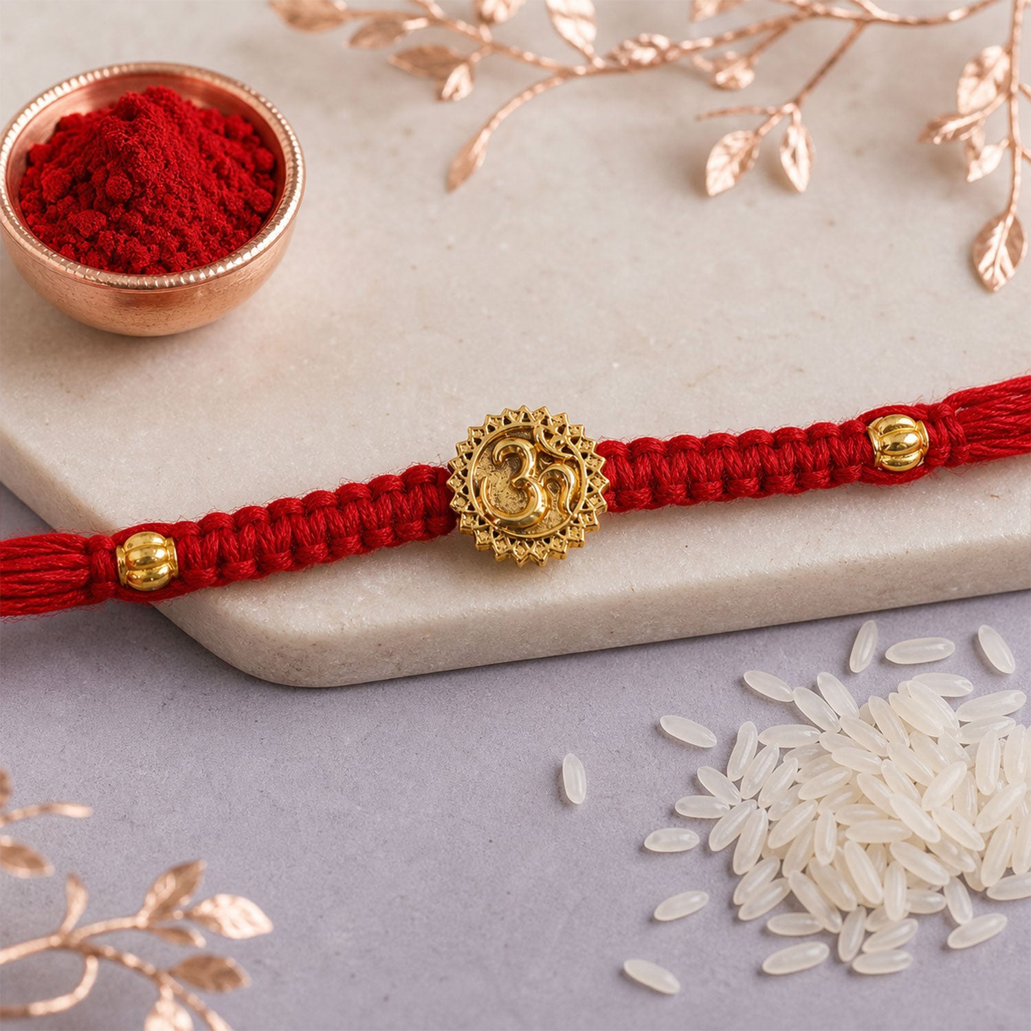Red Thread Rakhi with an Antique Gold Om Pendant and Beaded Accents