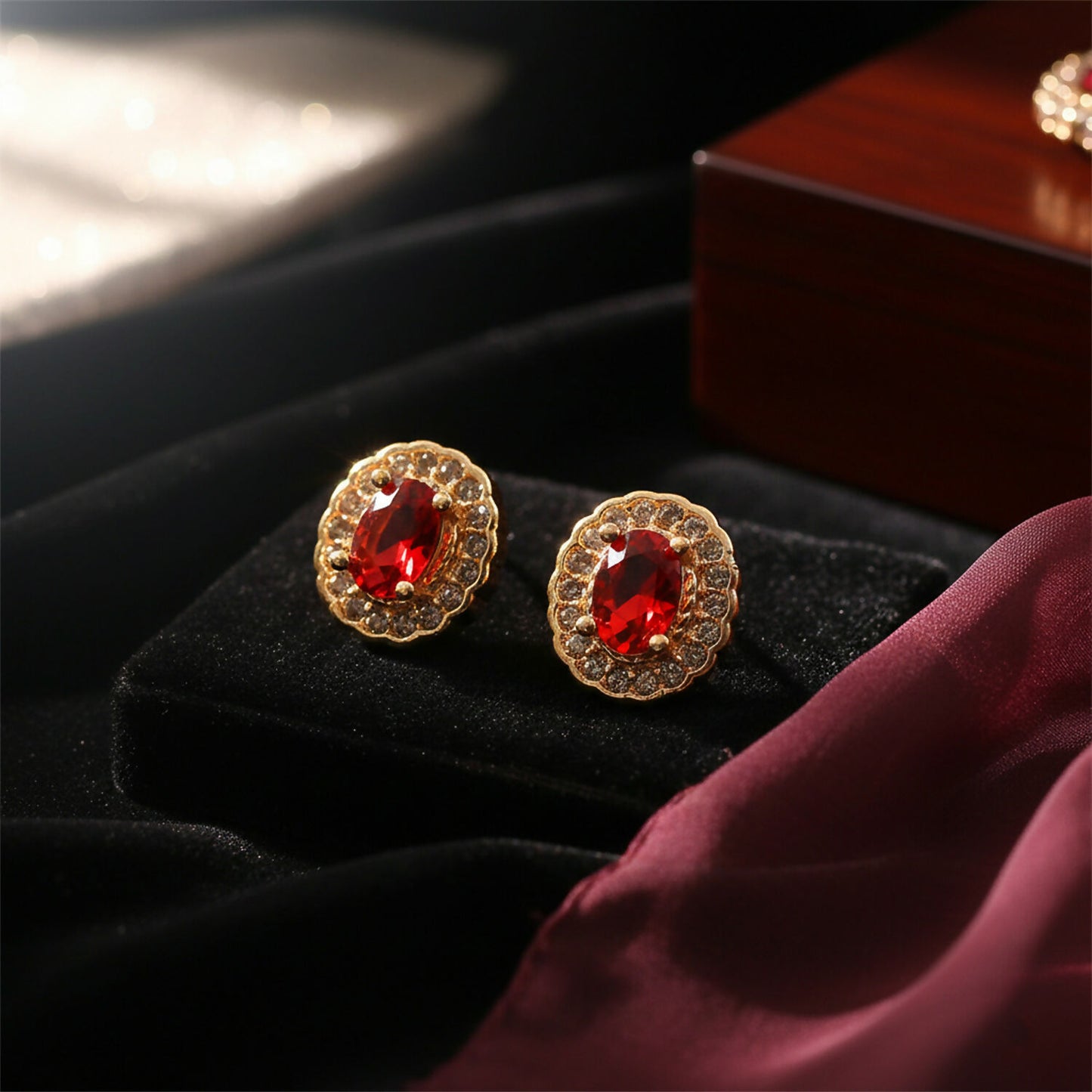 Red stone stud earrings featuring golden finish and crystal halo detail
