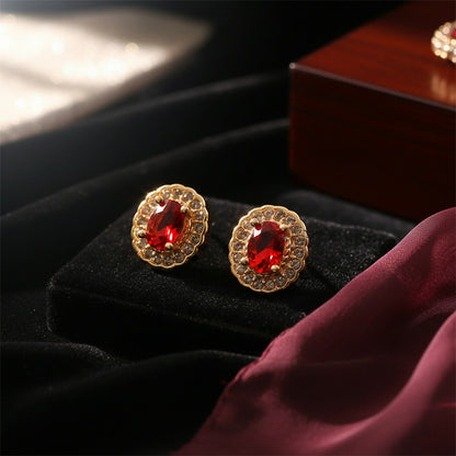 Red stone stud earrings featuring golden finish and crystal halo detail