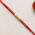 Minimal Red Thread Rakhi with Small Golden Bead Pendant Accents