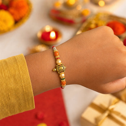 Red Thread Rakhi with Antique Gold Turtle Pendant and Beaded Accents