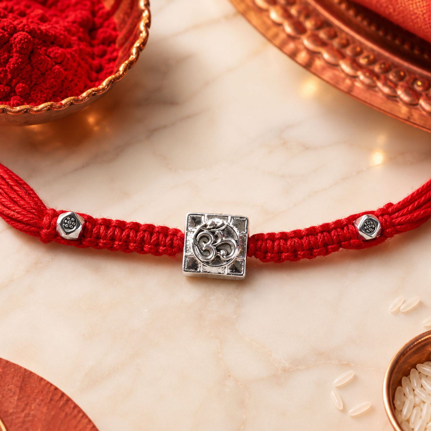 Red Braided Rakhi with Silver Om Pendant Set in a Square Frame