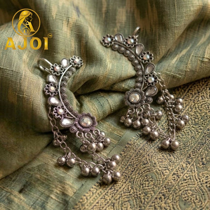 Close-up of intricate floral motifs on vintage silver ear cuff earrings