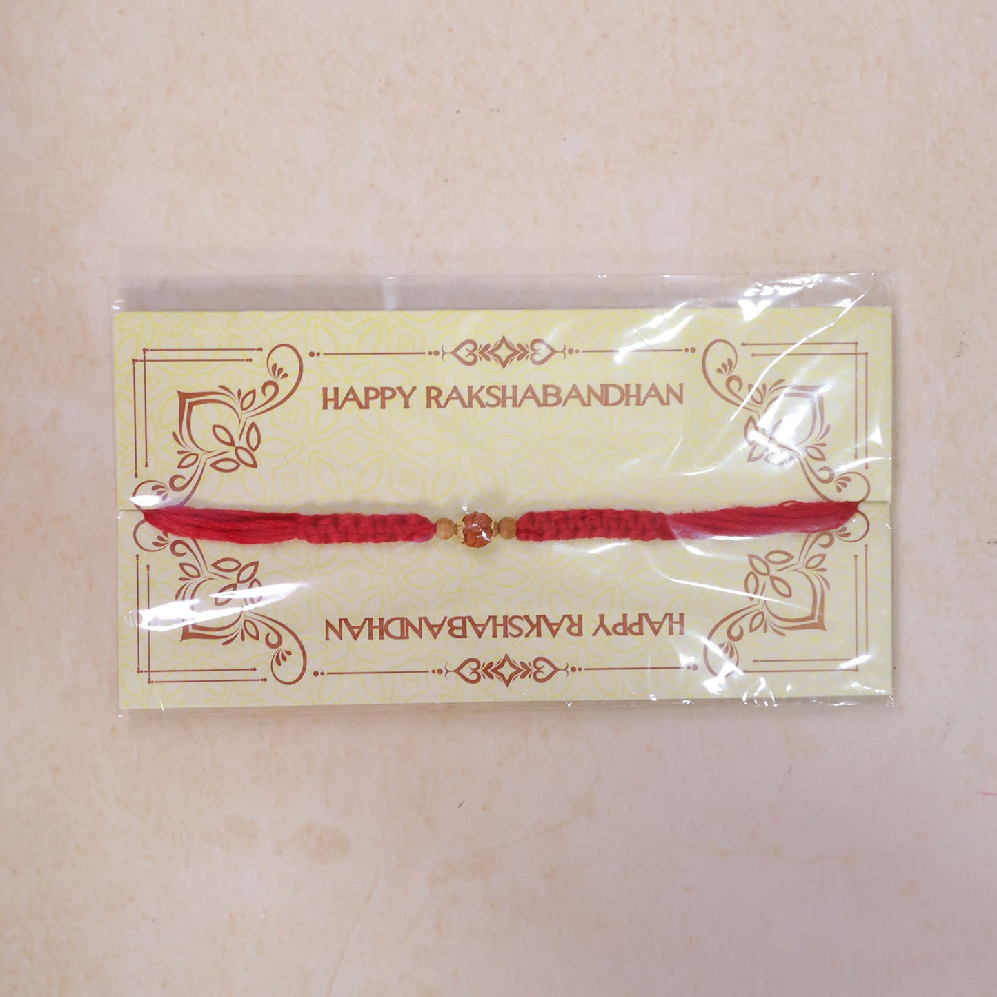 Red Braided Rakhi with a Natural Rudraksha Bead Pendant Accent