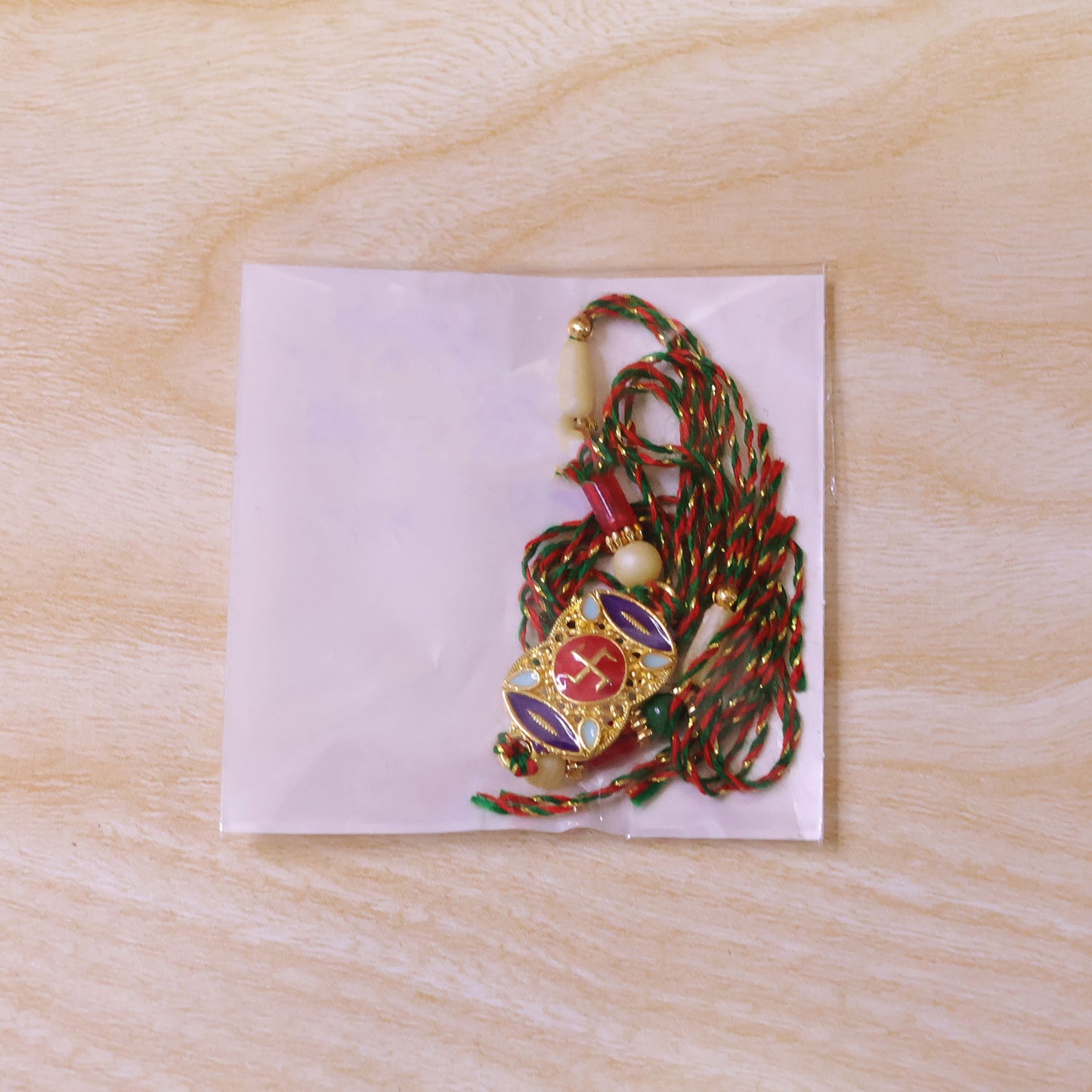 Festive Rakhi featuring Swastik Medallion and gold trims in display look for Gift Use