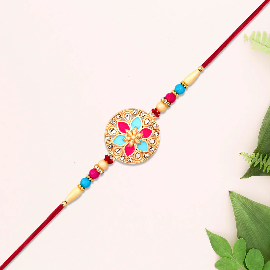 Front view of the elegant Floral Rakhi designed with pink and blue enamel accents.