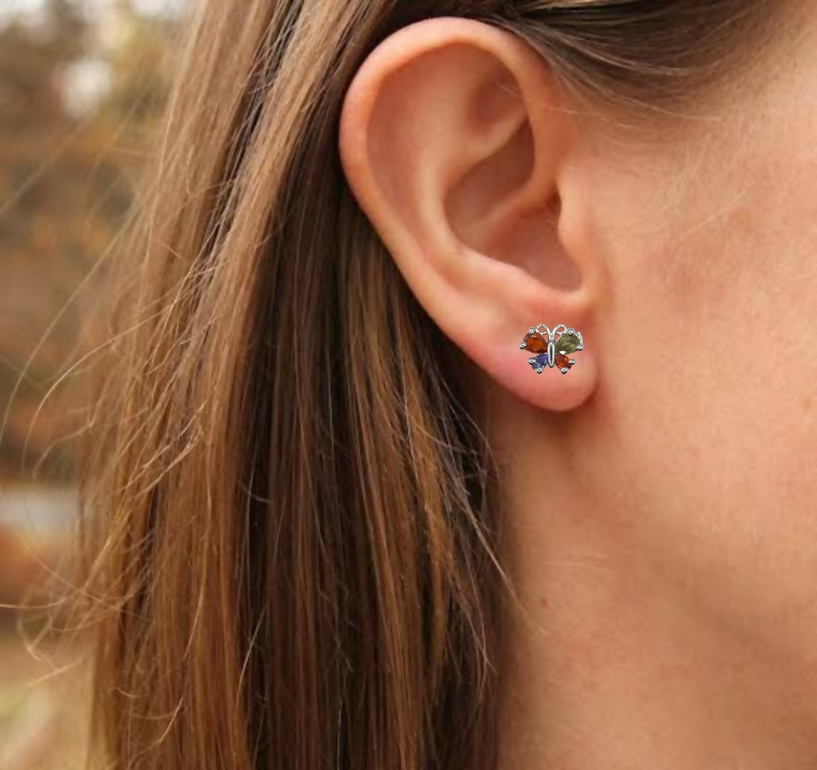 Multicolor zircon butterfly stud earrings arranged on a decorative surface highlighting intricate details
