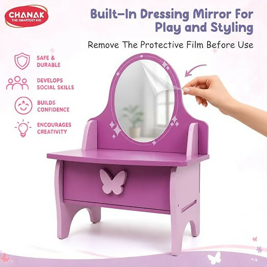 A hand peeling a protective film from the mirror of a purple and pink wooden vanity, emphasizing its play and styling use.