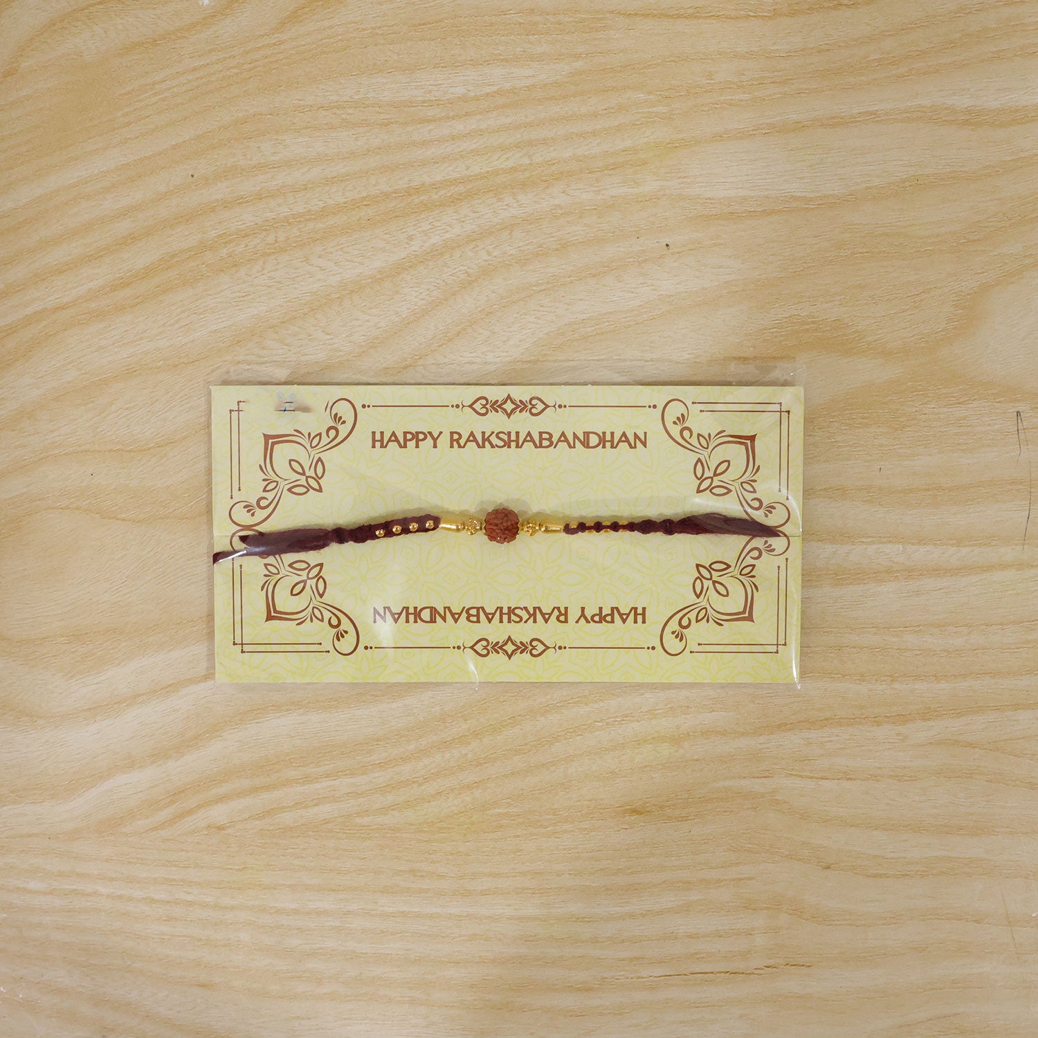 Red Braided Rakhi with a Rudraksha Bead and Wooden Bead Accents