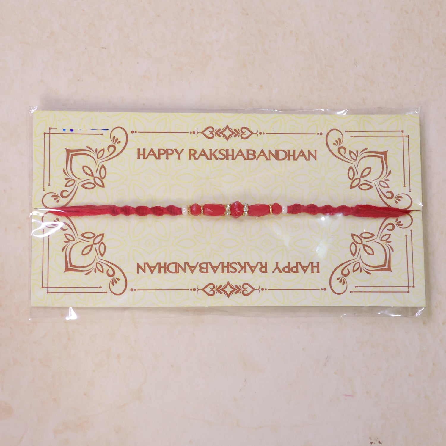 White Thread Rakhi with Smooth Red Oval Bead Accents