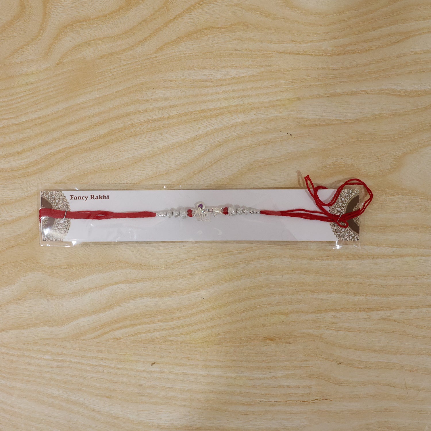 Elegant Radhe Silver Rakhi with Decorative Beads and Red Thread