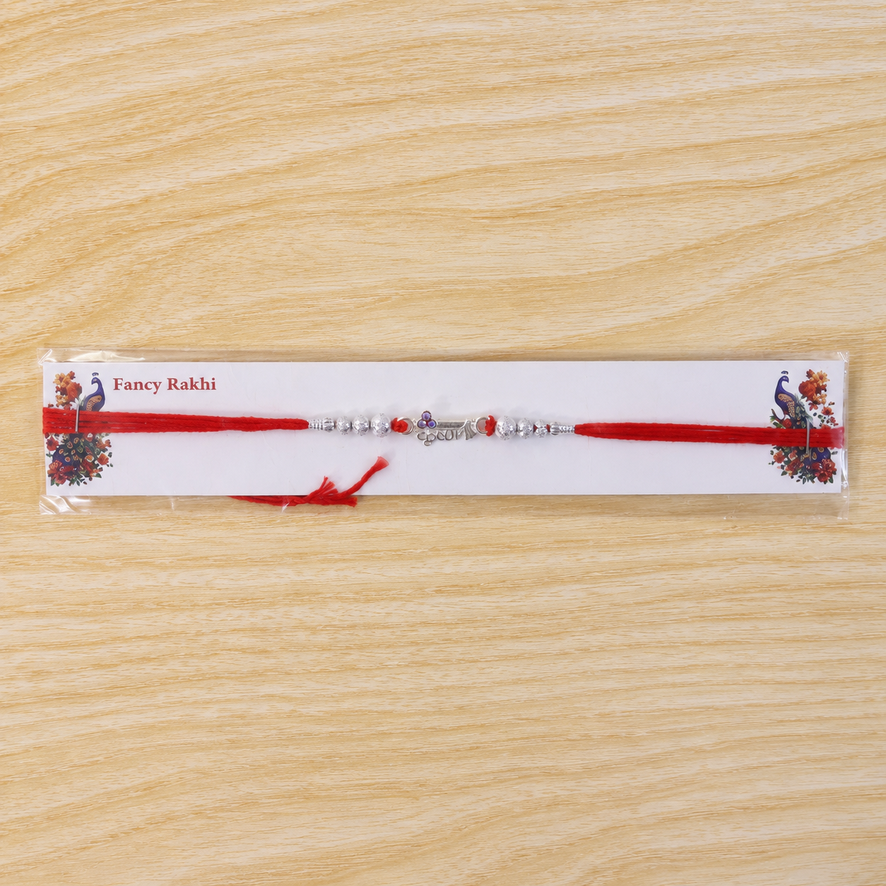 Silver Morpich Krishna Bead Rakhi with Tiny Purple Stone and Red Thread