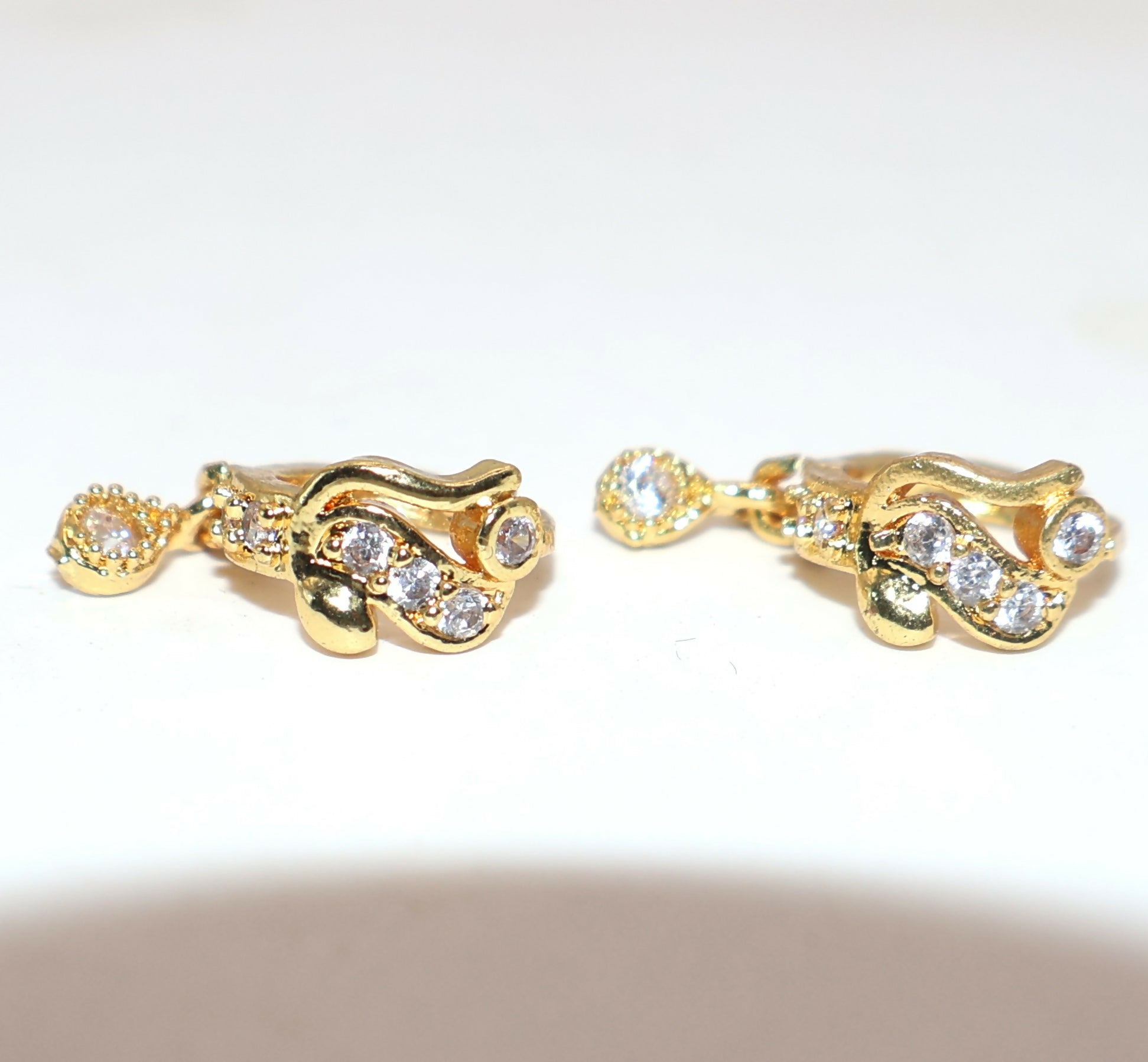 Stacked gold plated Bali style huggie hoop earrings showcasing CZ stones