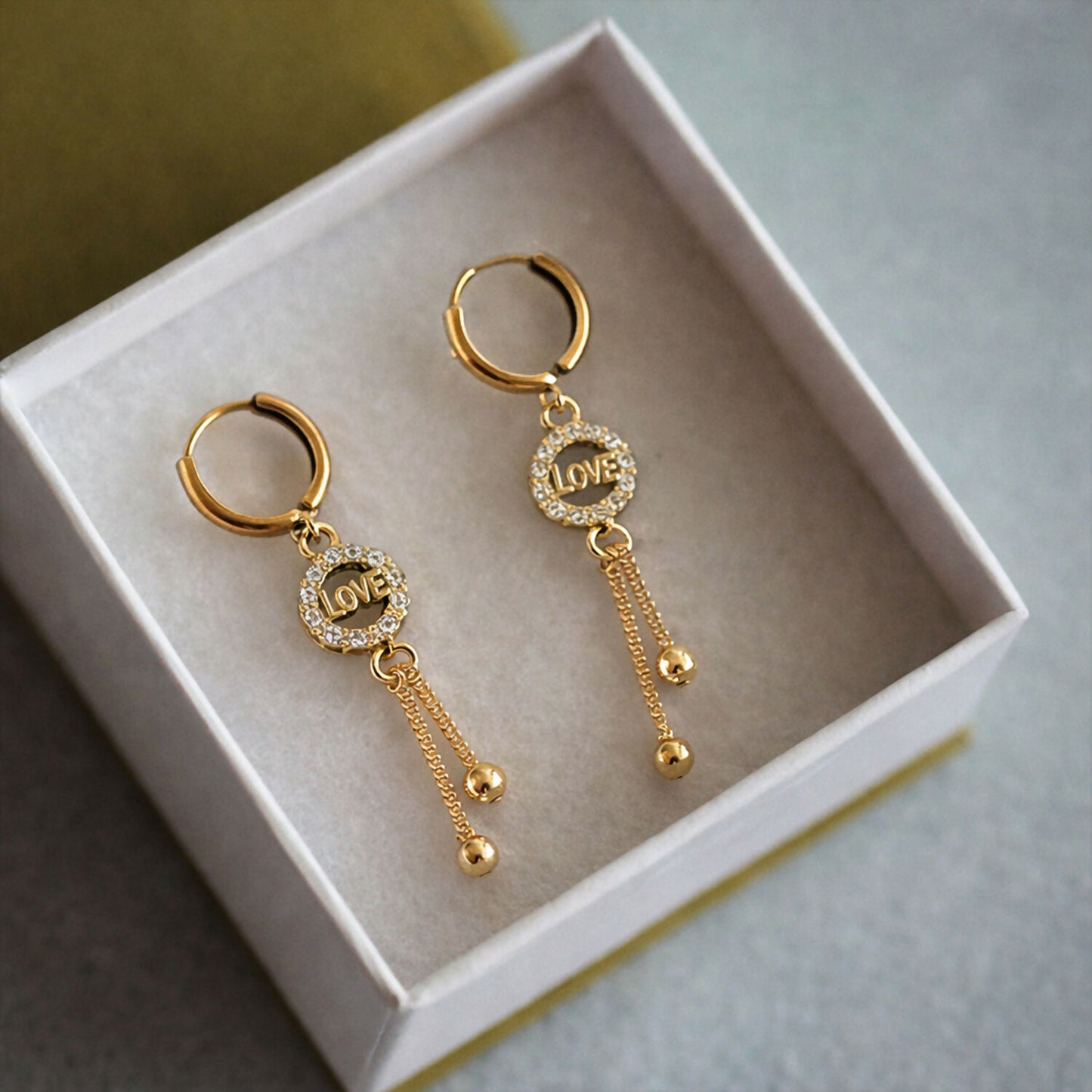 Side profile of elegant Love Charm Tassel Earrings with polished bead tassels