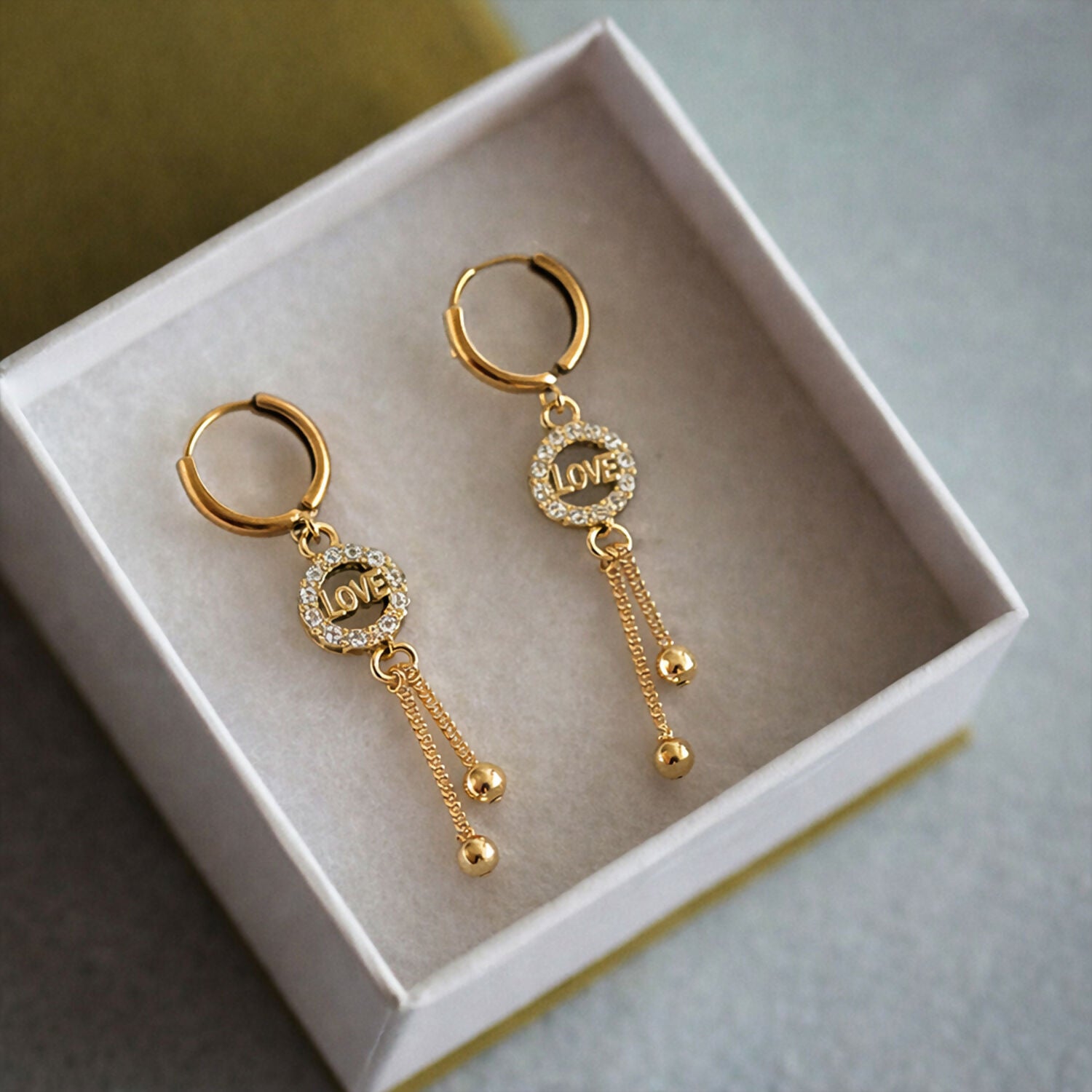 Side profile of elegant Love Charm Tassel Earrings with polished bead tassels