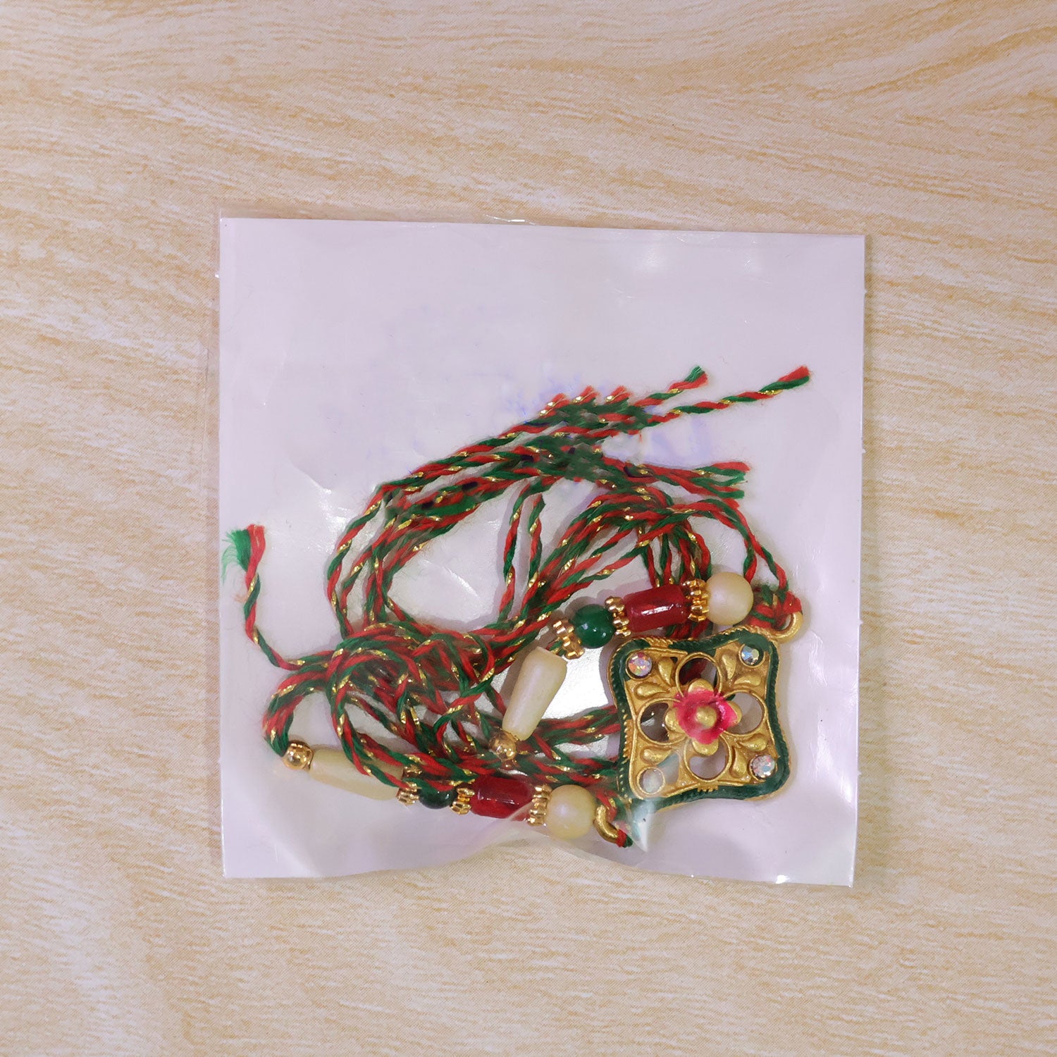 Green Enamel Kite Shaped Pendant Rakhi with Red Flower Center