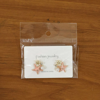 Pink starfish pearl earrings styled on model ear