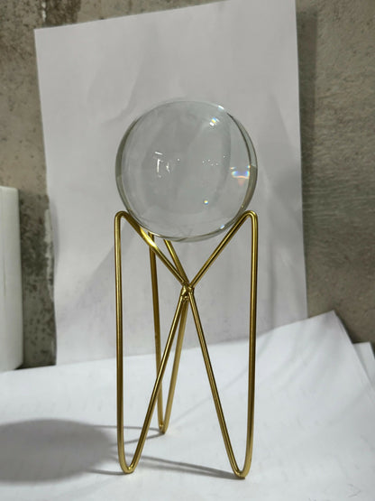 Elegant living room centerpiece featuring crystal glass sphere on golden stand