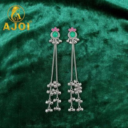 Front view of green stone silver ghungroo chain earrings with intricate detailing