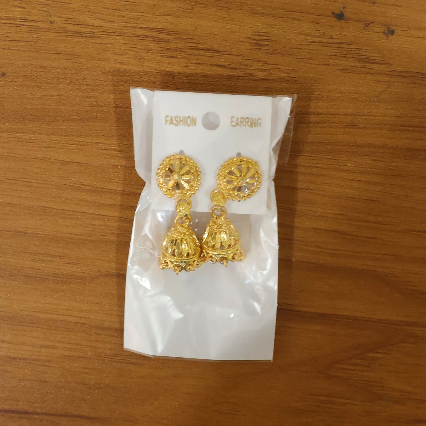 Pair of gold plated floral jhumka earrings on white background