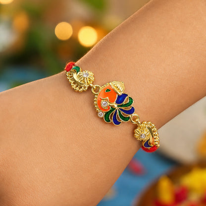 Gold-Toned Lord Ganesha Rakhi with Peacock Feather Enamel, Crystal Accents & Designer Red Thread